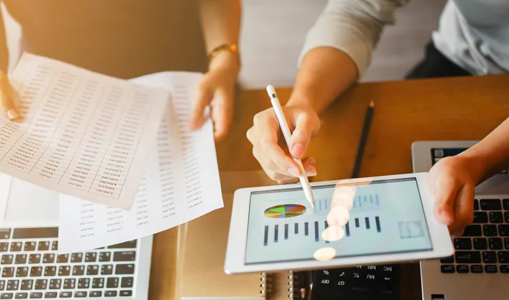 a facilities manager compares data stored digitally to a printed report