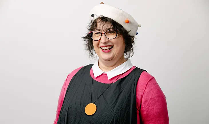 Maree Lee, senior consultant at FMI, smiles at the camera wearing a pink beret