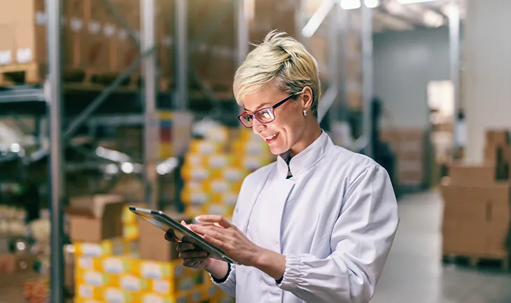 a woman runs through compliance checks for the facility on a tablet device