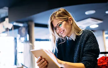 A facilities manager smiles at organised data on a tablet device