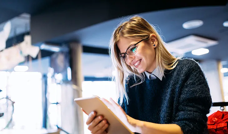 A facilities manager smiles at organised data on a tablet device