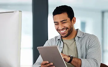 A facilities manager smiles as they look at information on a tablet device
