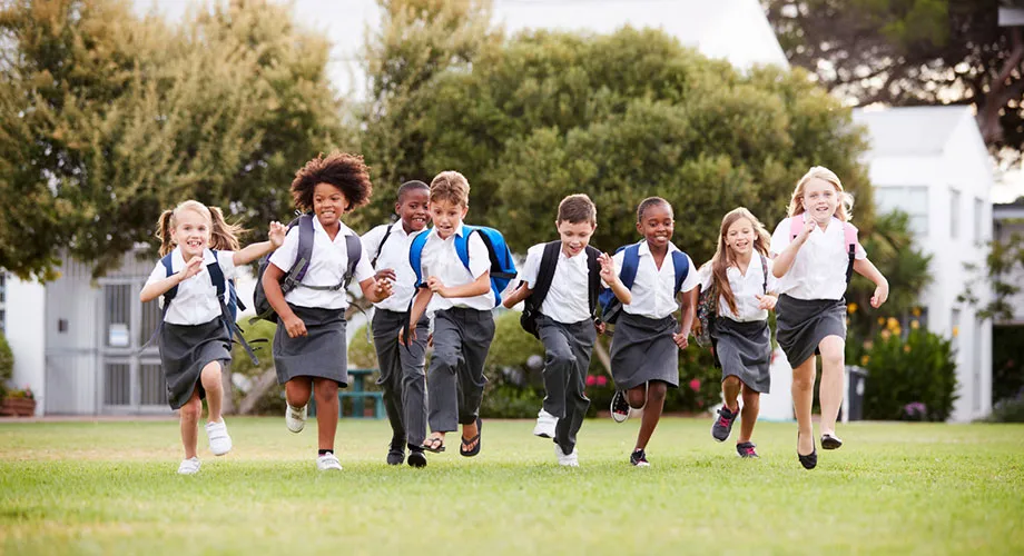 A group of students walking along a footpath outside of a university