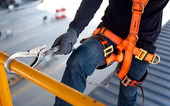 A worker uses a safety harness while working at height