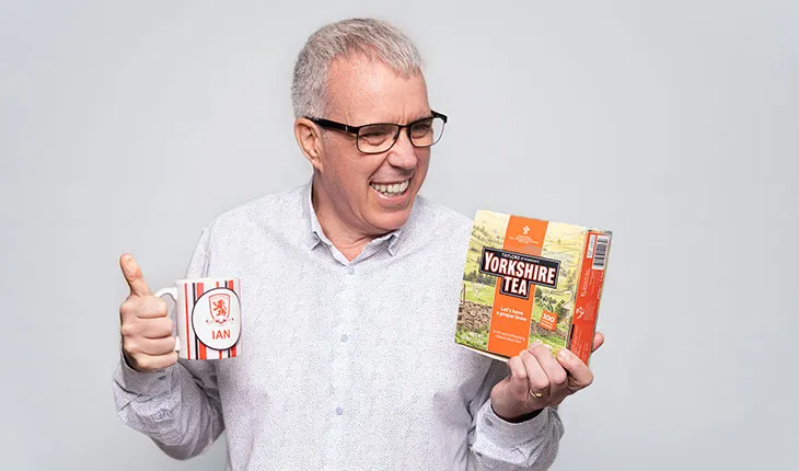 Headshot of Ian Jackson, holding a football club mug and a box of yorkshire tea