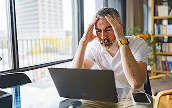 A facilities manager gives a laptop a frustrated look