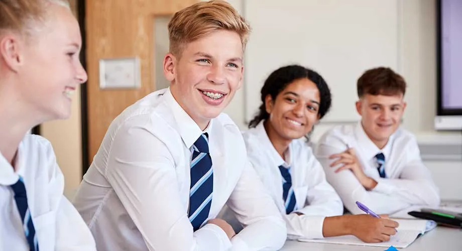 A group of students walking along a footpath outside of a university