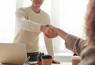 image of two facility compliance managers shaking hands