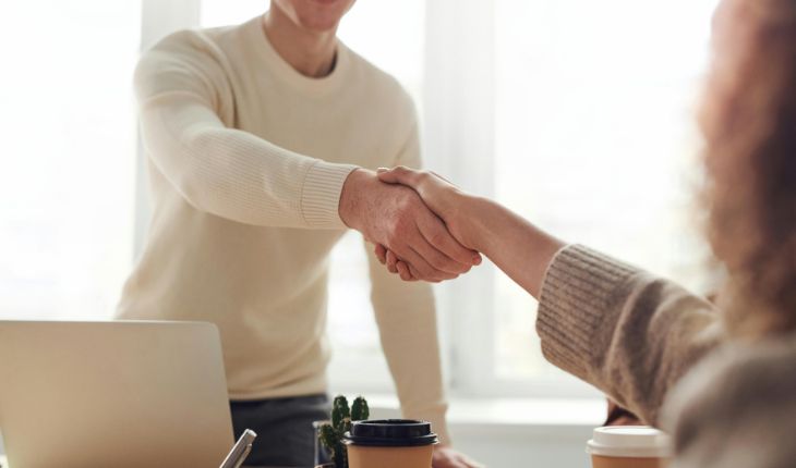 image of two facility compliance managers shaking hands