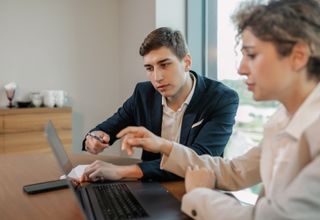 image of two facility managers viewing a laptop device