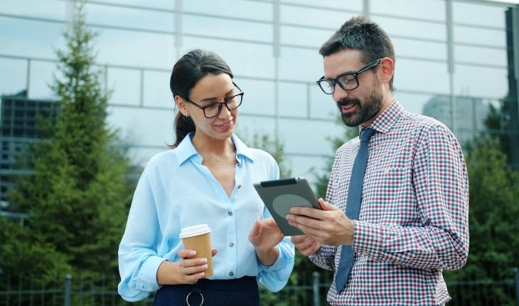 image of two facility managers in conversation, using a tablet device