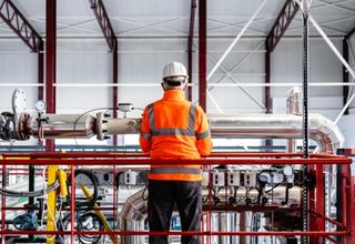 image of a tradesperson standing in front of a facility asset