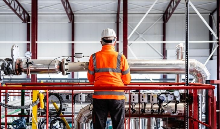 image of a tradesperson standing in front of a facility asset