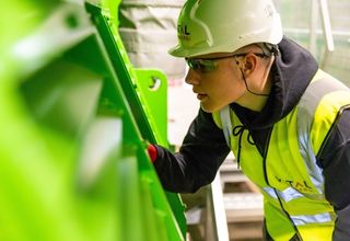 image of a high-vis contractor examining asset equipment
