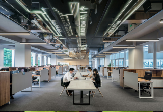 image of three facility managers seated at a table inside a corporate office interior