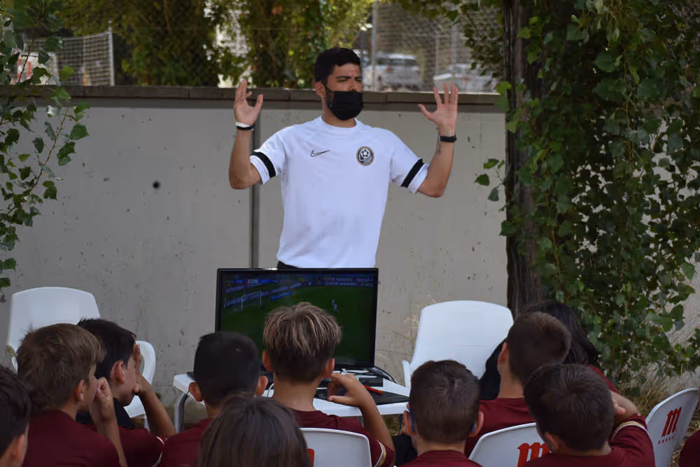 entrenador explicando teoria a los niños de la academia