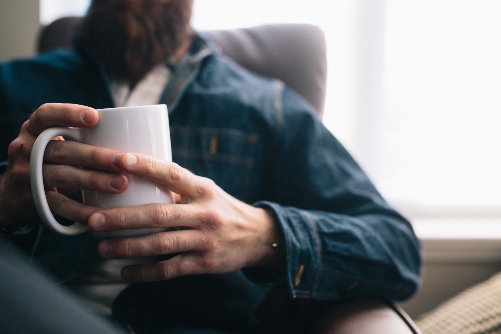 A close-up of a white person's hands holding a mug.