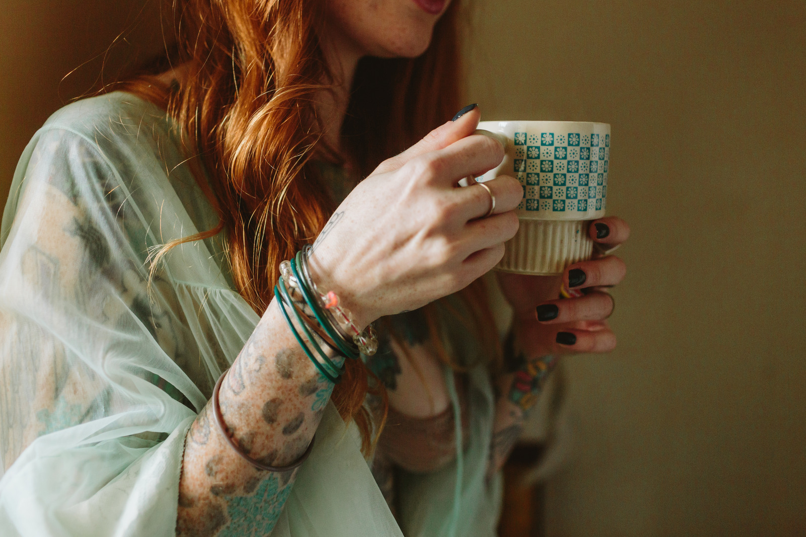 A close-up of a woman's hands holding a mug of tea.