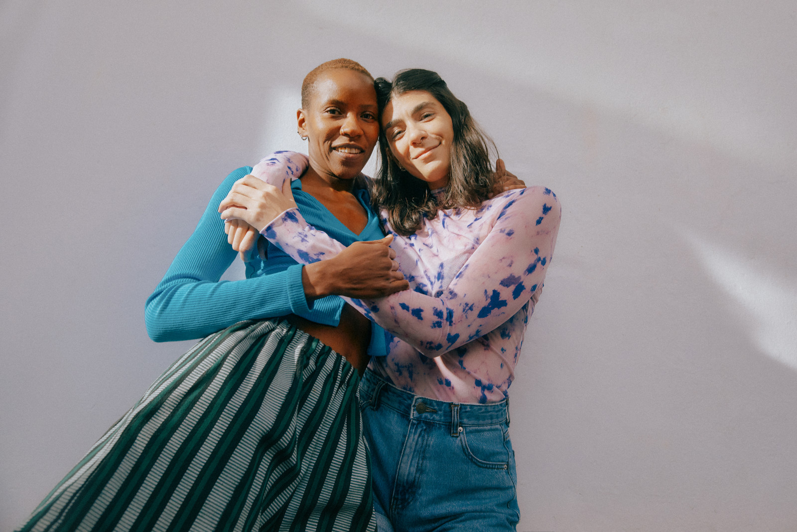 Two people embracing and smiling down at the camera.