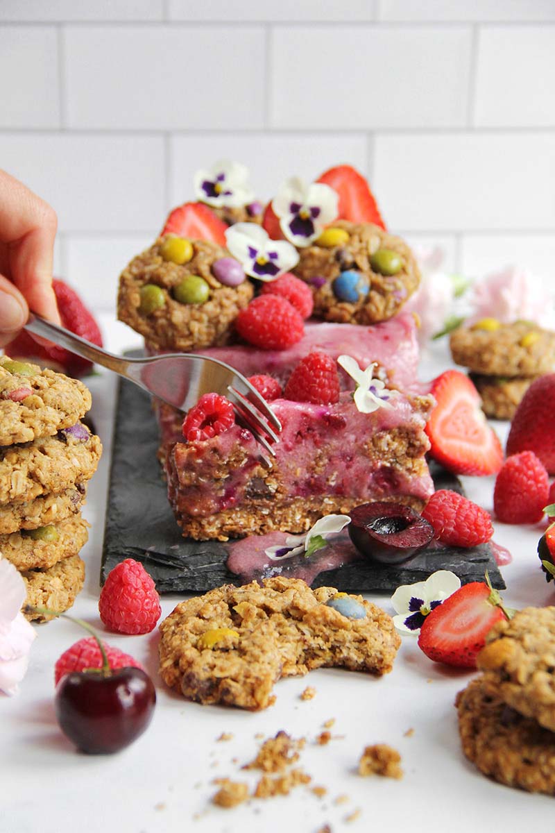 Woman's hand taking a forkful of healthy berry nicecream cake.