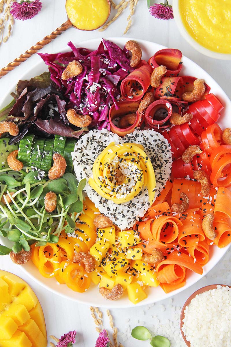 Close-up of a beautiful, healthy bowl meal with rice and colorful raw vegetables.