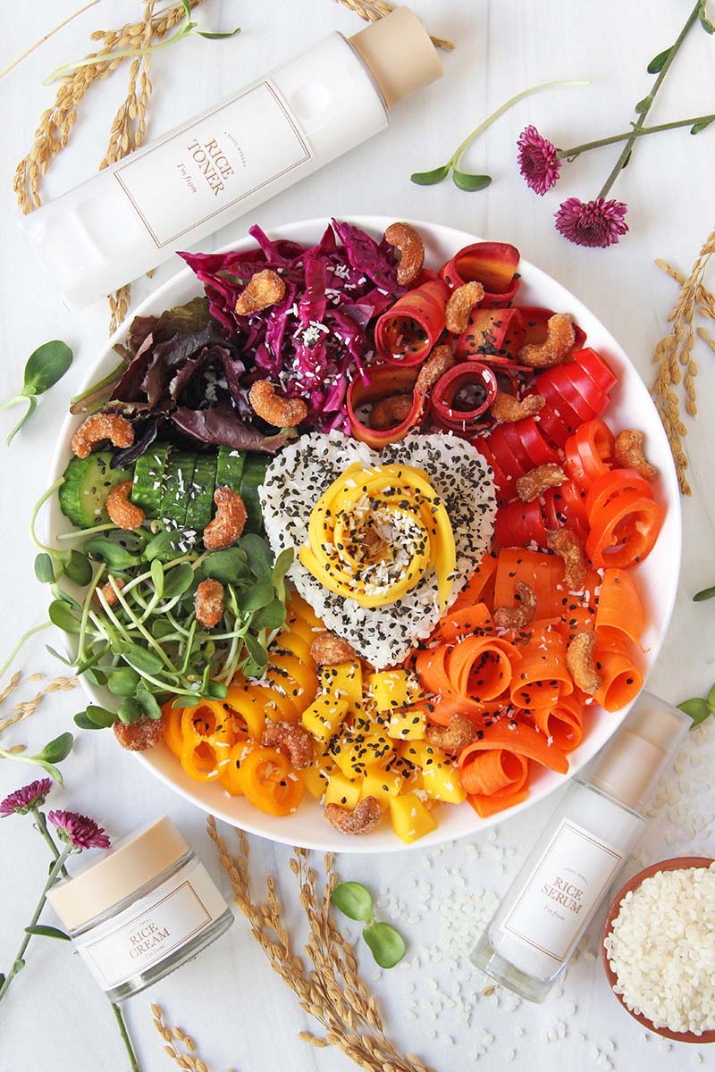 Colorful vegan bowl meal with rice and vegetables, shown on a white background.