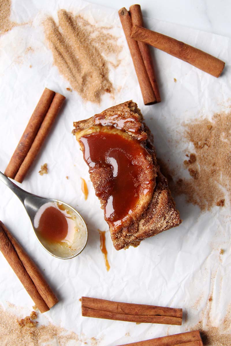 Close-up of a slice of apple cider donut cake drizzled with caramel.