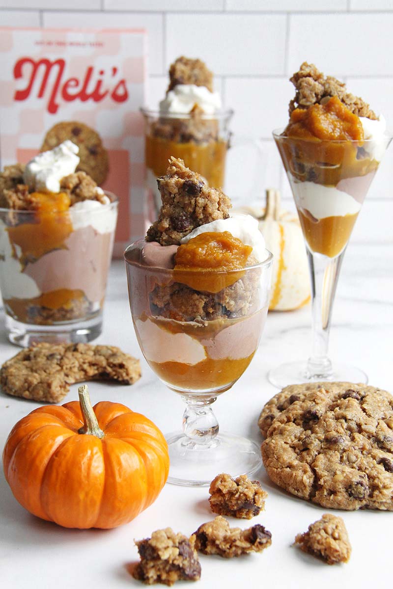Four pumpkin cookie trifles shown in a white kitchen with a box of cookie baking mix in the background.