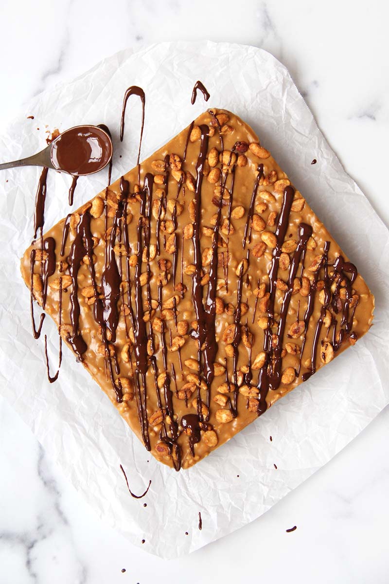 Vegan Snickers brownies shown from above (before cutting), drizzled with dark chocolate.