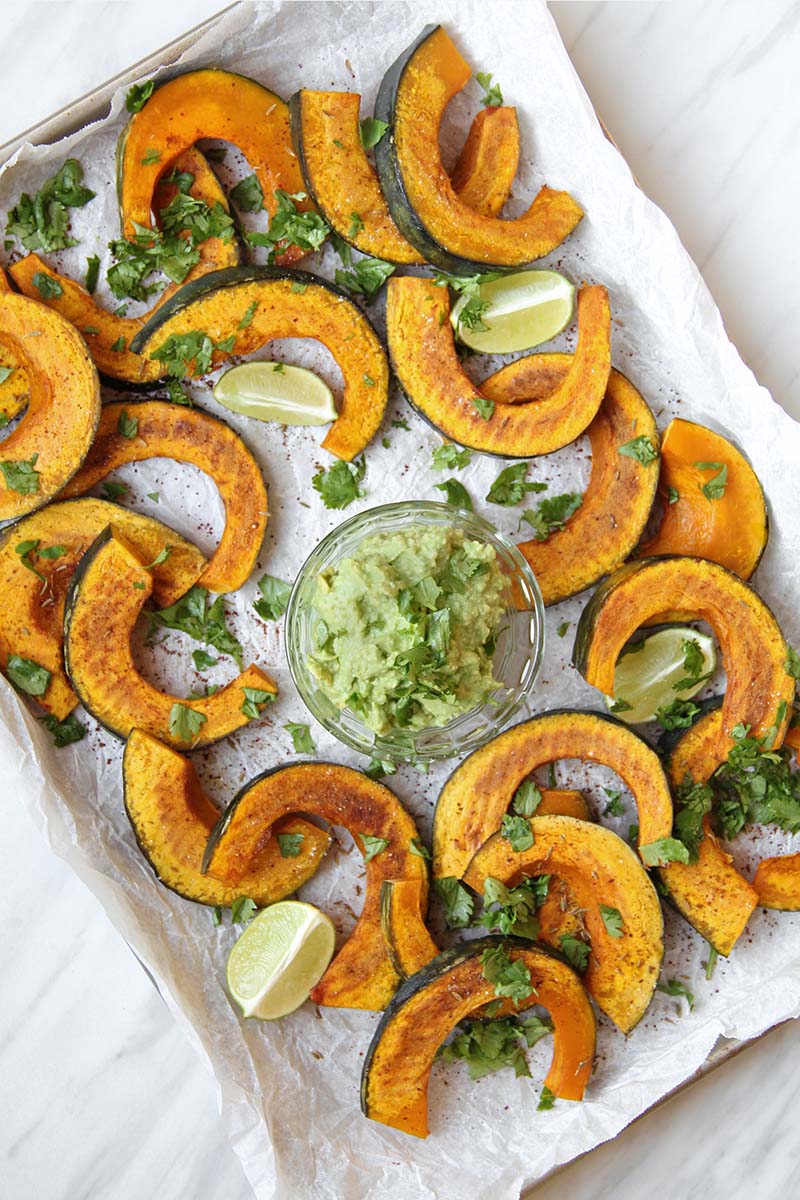 Roasted kabocha squash dippers seasoned with chili and cumin, garnished with fresh cilantro and lime, served with creamy guacamole.