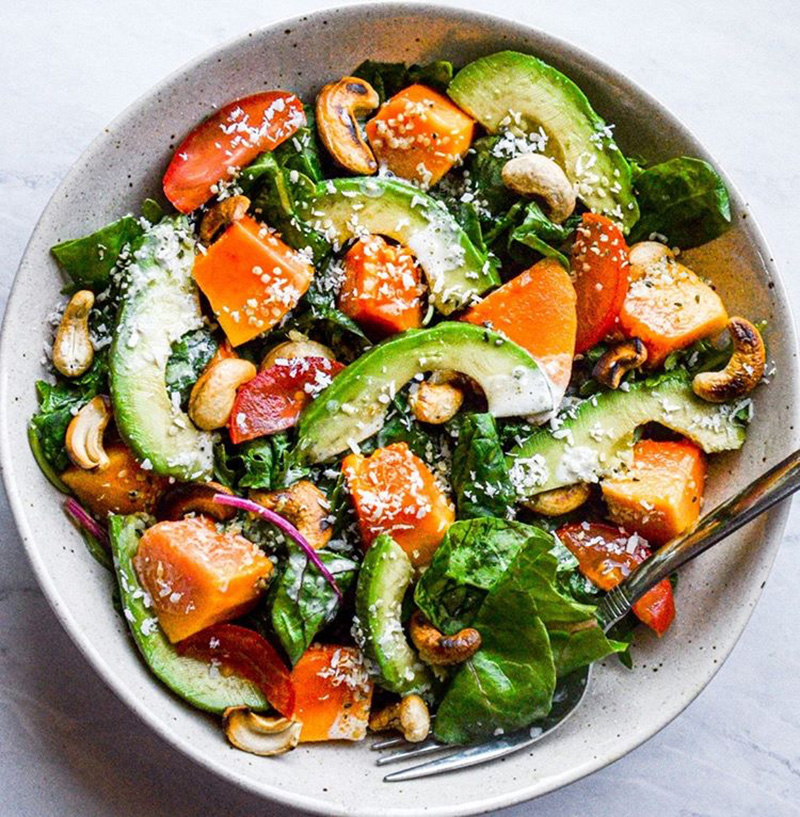 Unique healthy salad dressing recipe using coconut as the base, shown on a tropical salad
