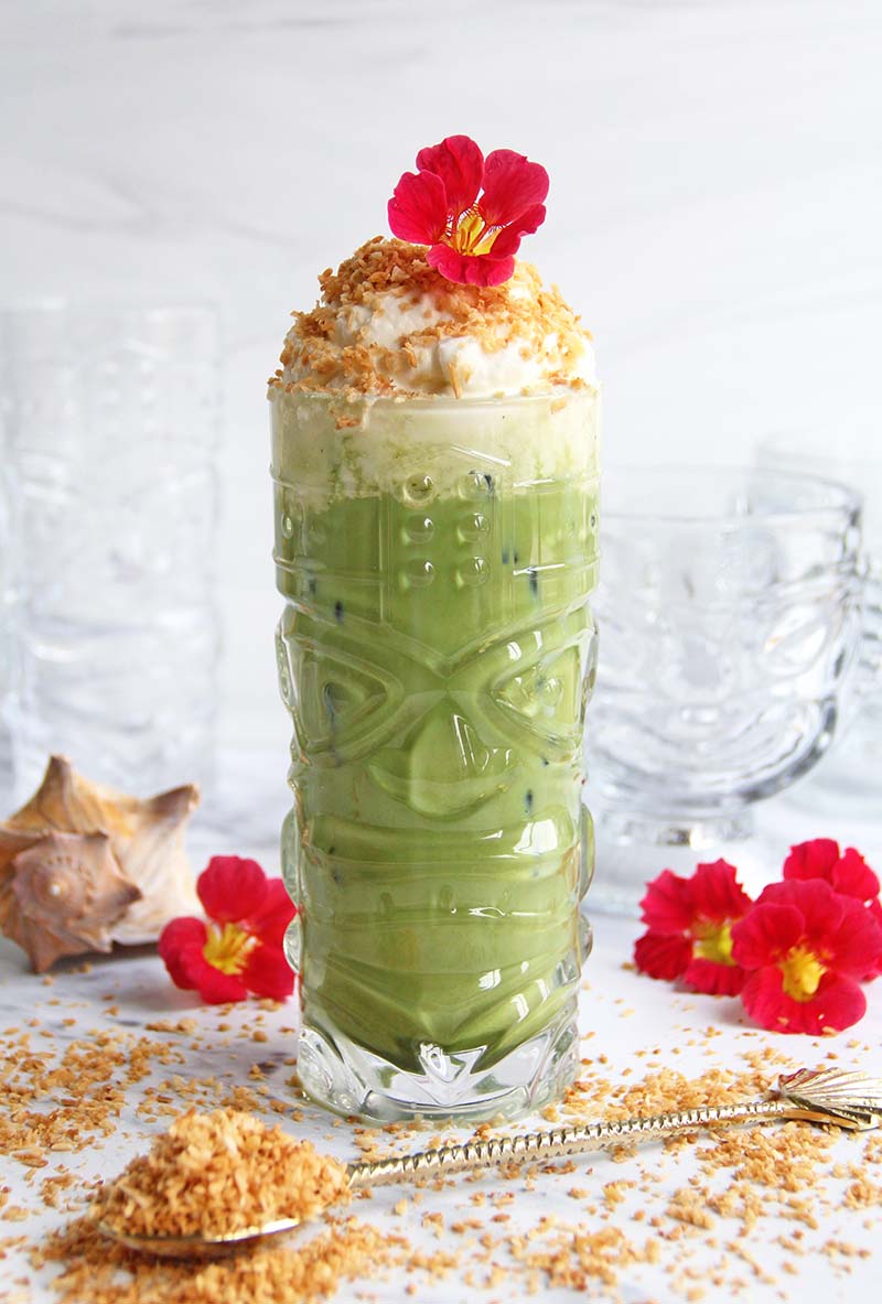 Hawaiian-inspired Toasted Coconut Matcha Latte, shown with seashells and tropical flowers.