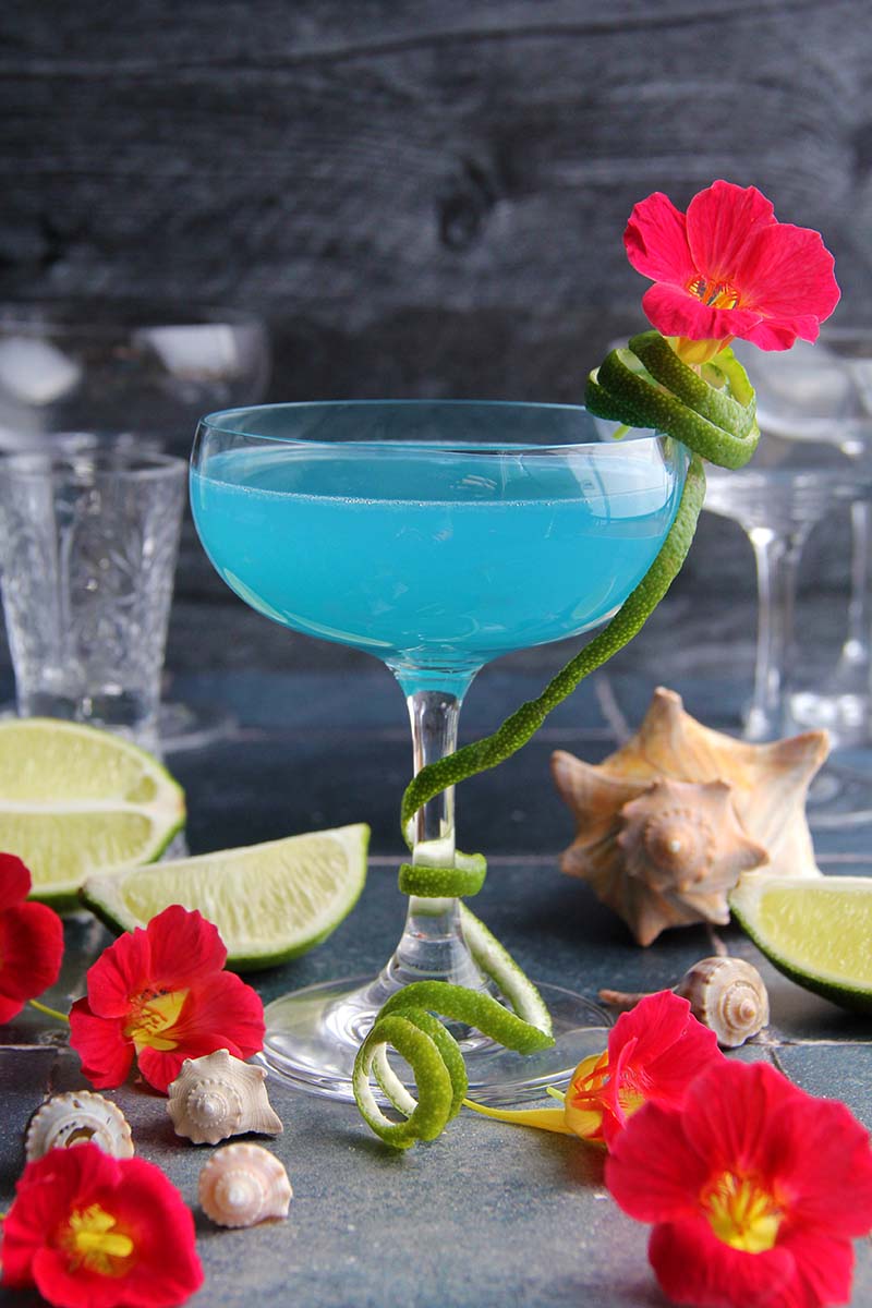 Close-up of a Blue Coconut Daiquiri in a coupe glass, showing the vibrant light blue color.