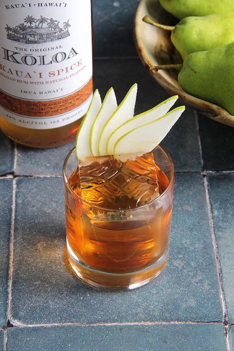 A cozy Koloa Spice Rum Old Fashioned cocktail with pear garnish.