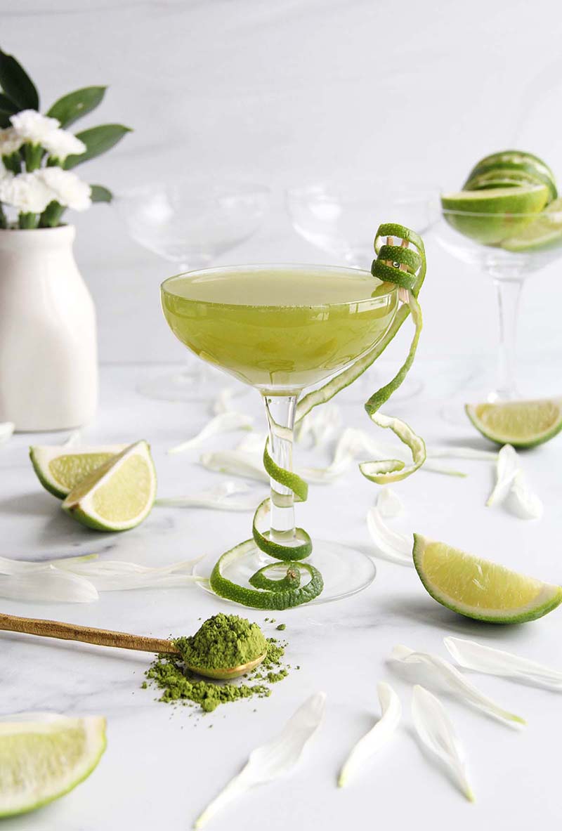 A matcha and Koloa Coconut Rum daiquiri, shown in a white kitchen with spring flowers.