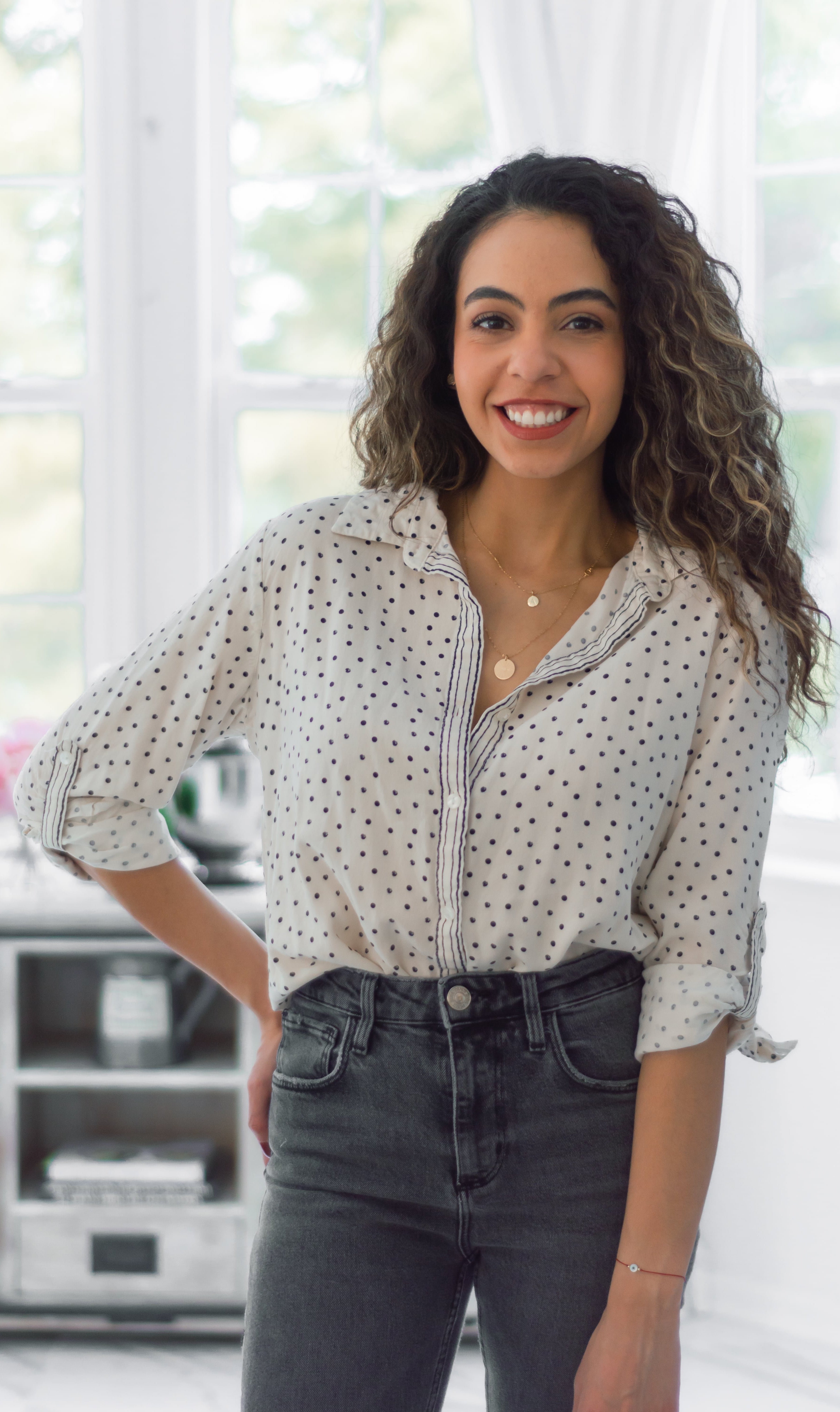 Girl standing with hand on hip smiling.