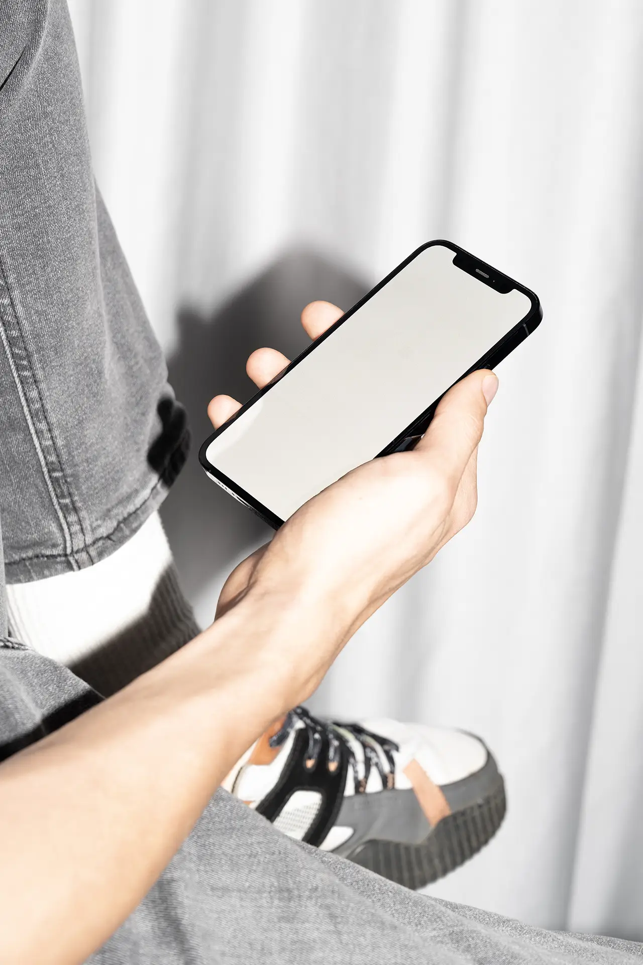 Blank iPhone Mockup held in hand for displaying mobile app or web design projects.