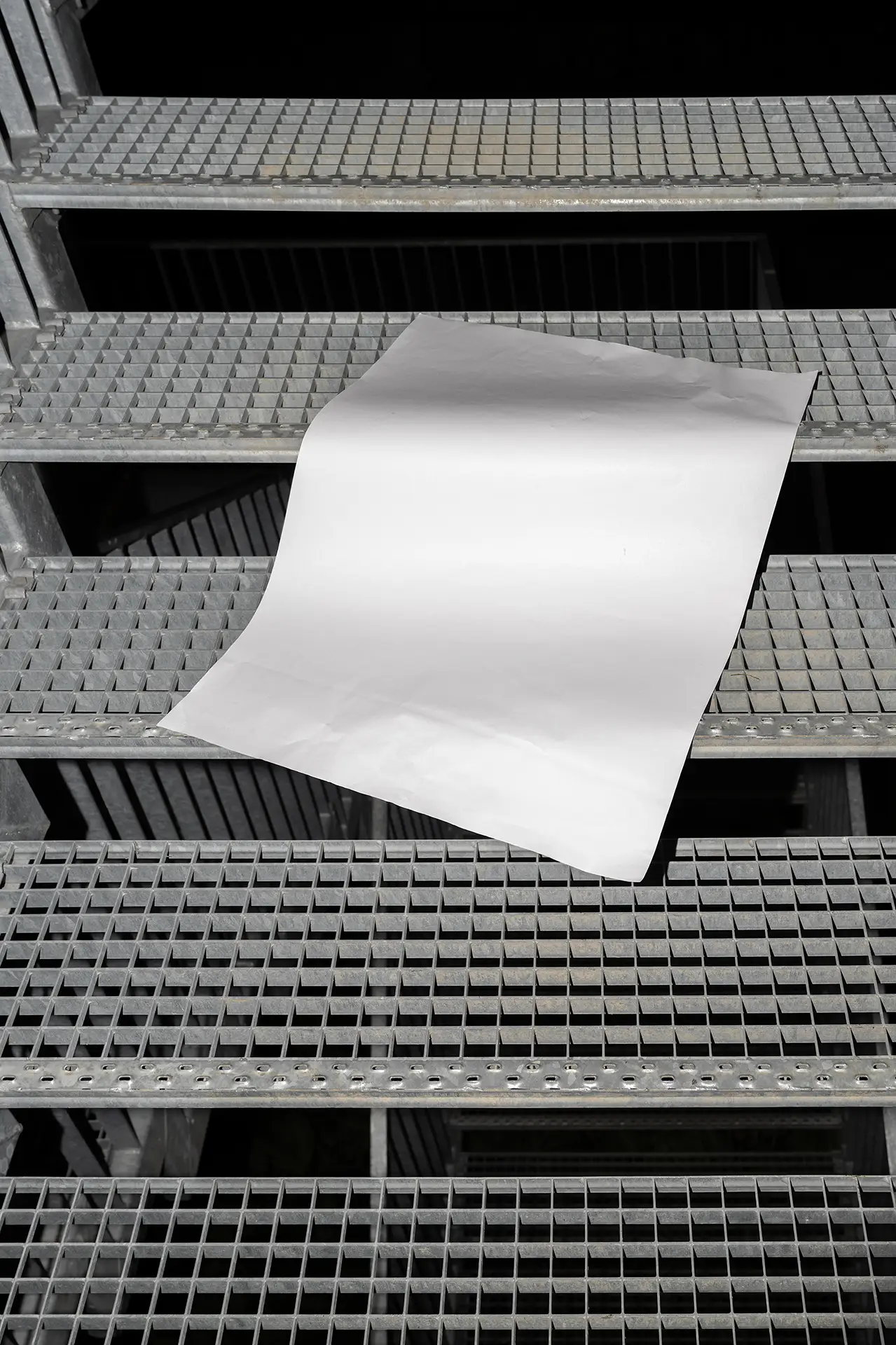 Blank Poster Mockup with A2 paper on metal staircase in industrial setting.