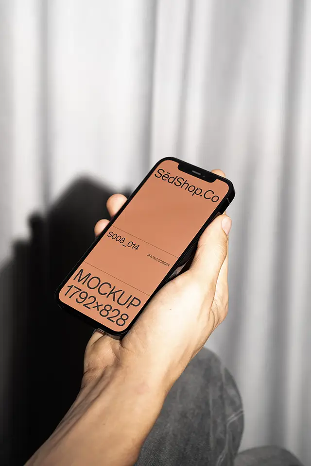 iPhone Mockup held in hand with flash lighting against soft curtain background.