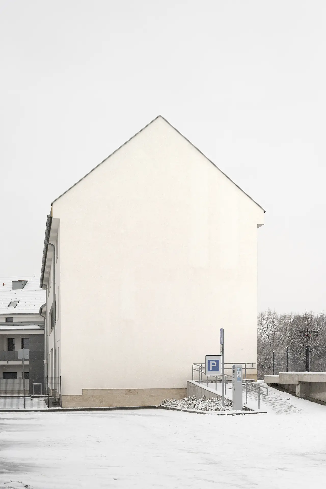 Blank vertical bus stop poster mockup in a snowy outdoor station with frosted trees and soft diffused overcast light.