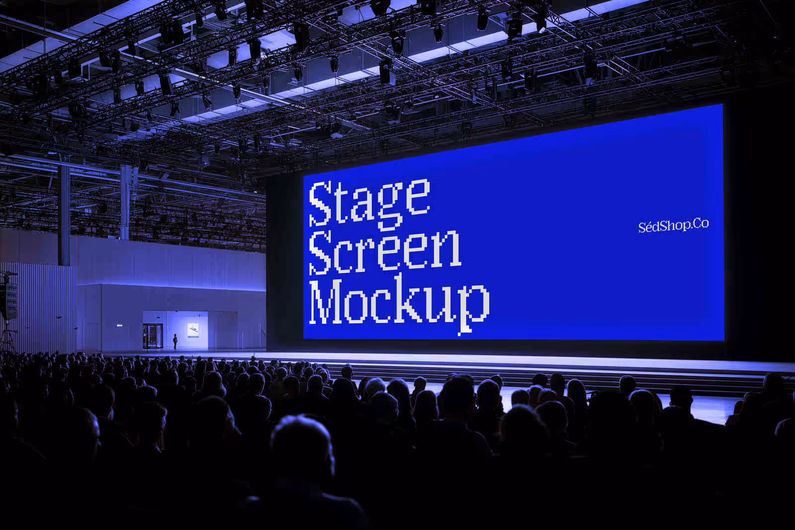 A conference stage LED screen showing a blue gradient design above an audience at an event.