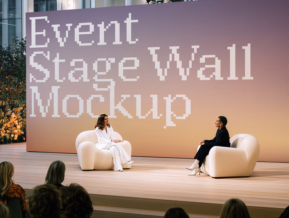 A large conference stage screen showing the SedShop.Co logo behind two speakers on a stage with an audience.
