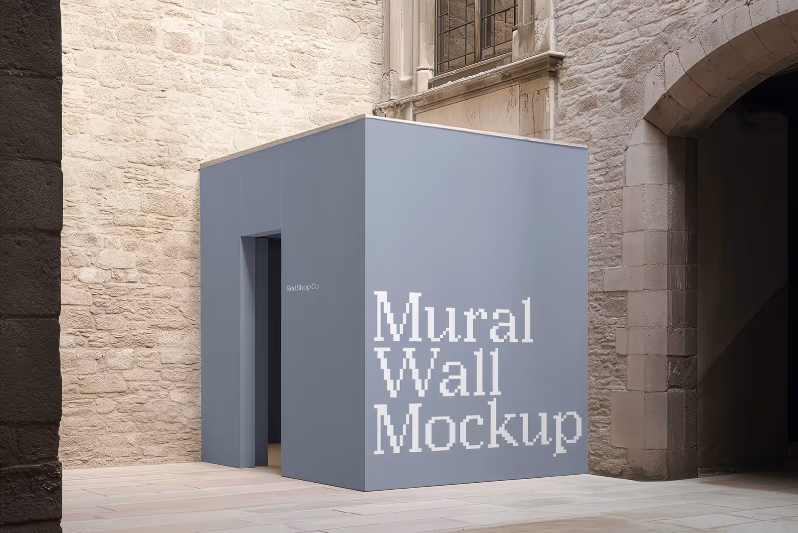 A bold red mural wall with a warm gradient design in a sunlit stone courtyard.