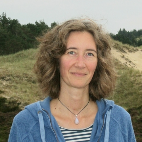 a portrait of Kathrin George taken on the island of Amrum with the dunes behind her