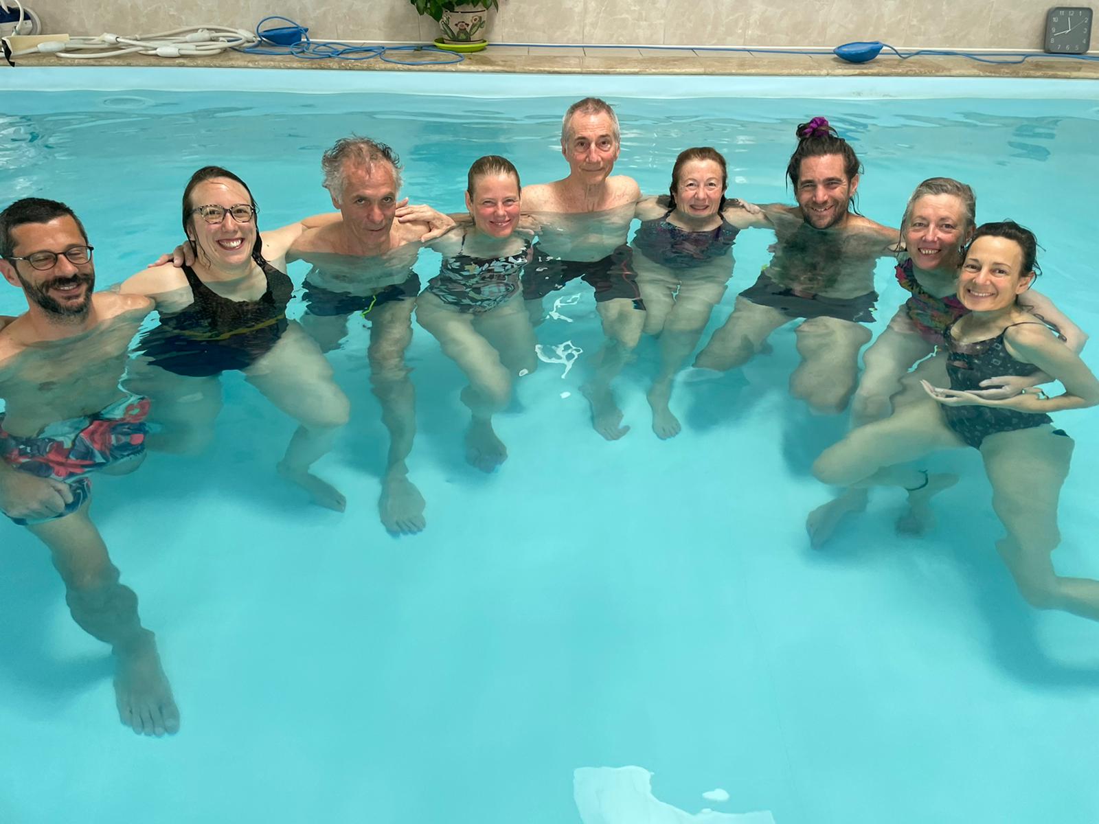 a class portrait from a training in France, everyone standing in the water