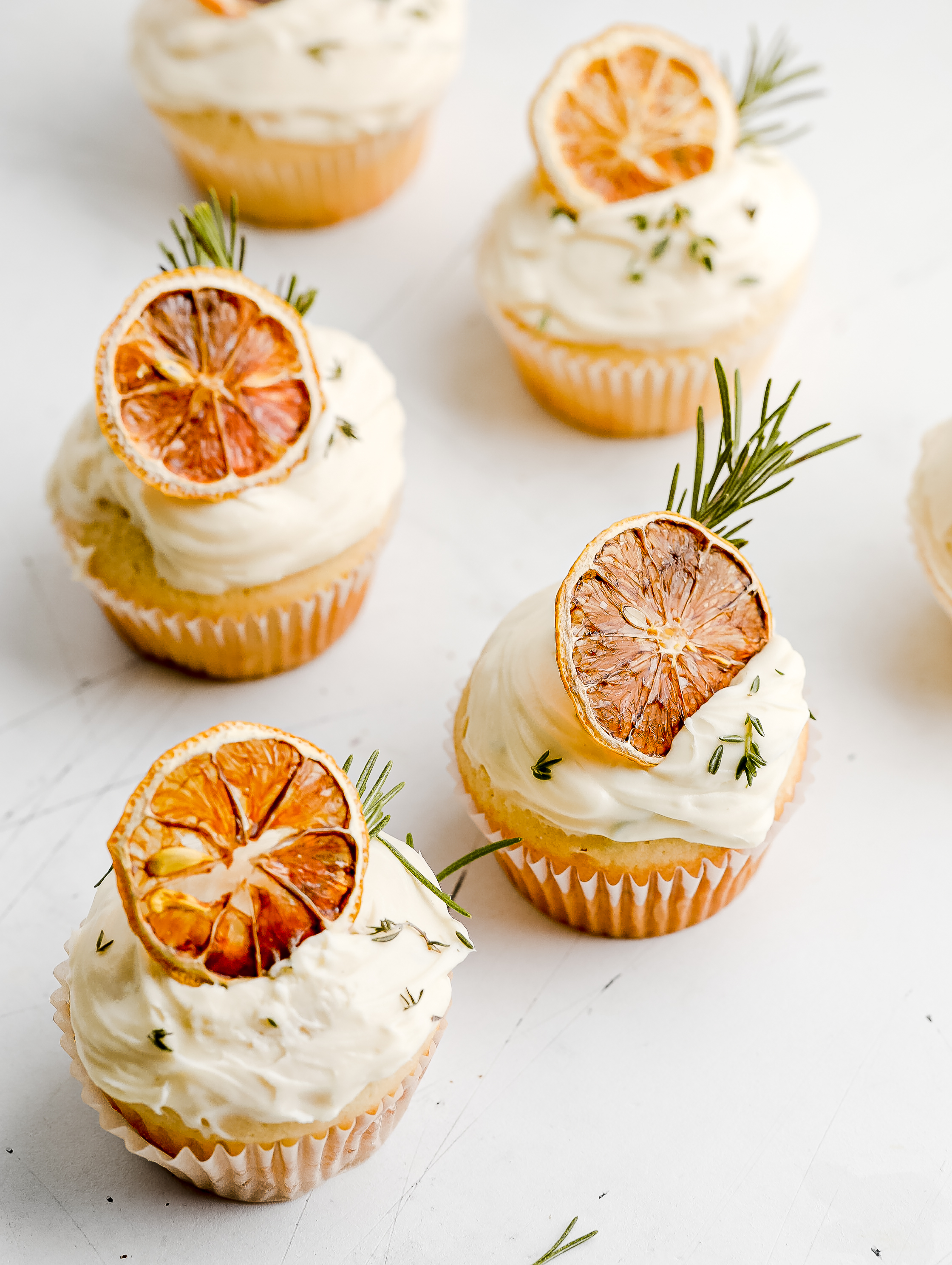 Lemon, rosemary and thyme cupcakes topped with swirls of lemon-mascarpone cream