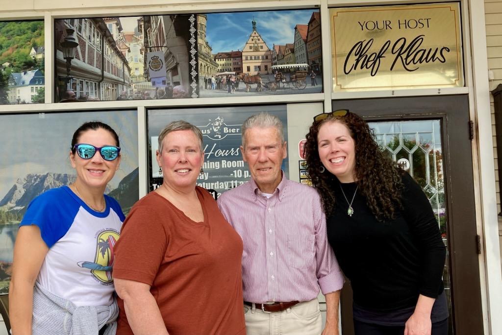 Writer and Editor Bridget Houlihan poses with her family in front of a restaurant
