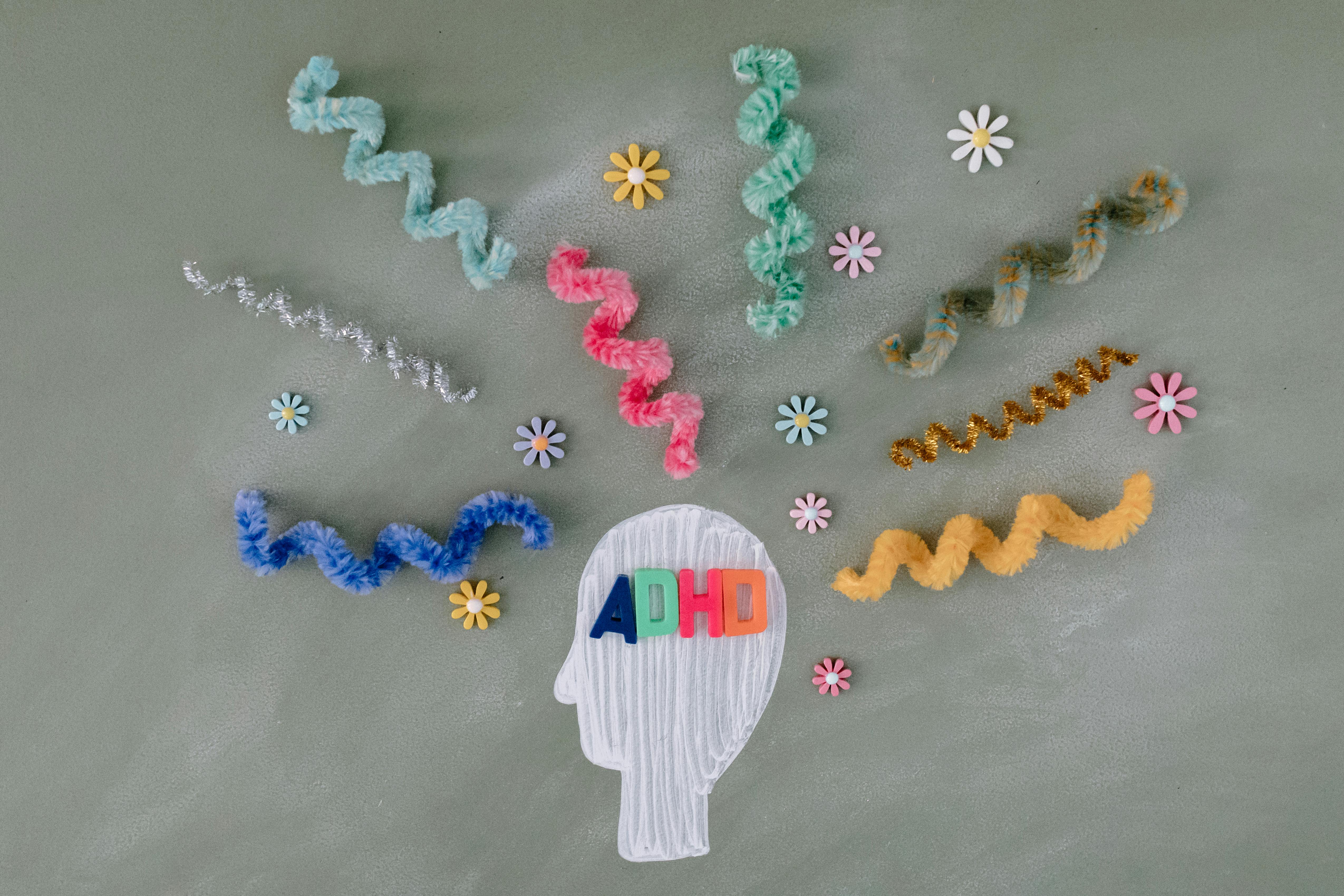 Head with pipe cleaners and flowers that says ADHD