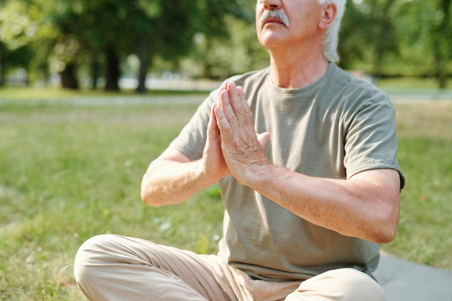 Older man breathing with hands at heart center