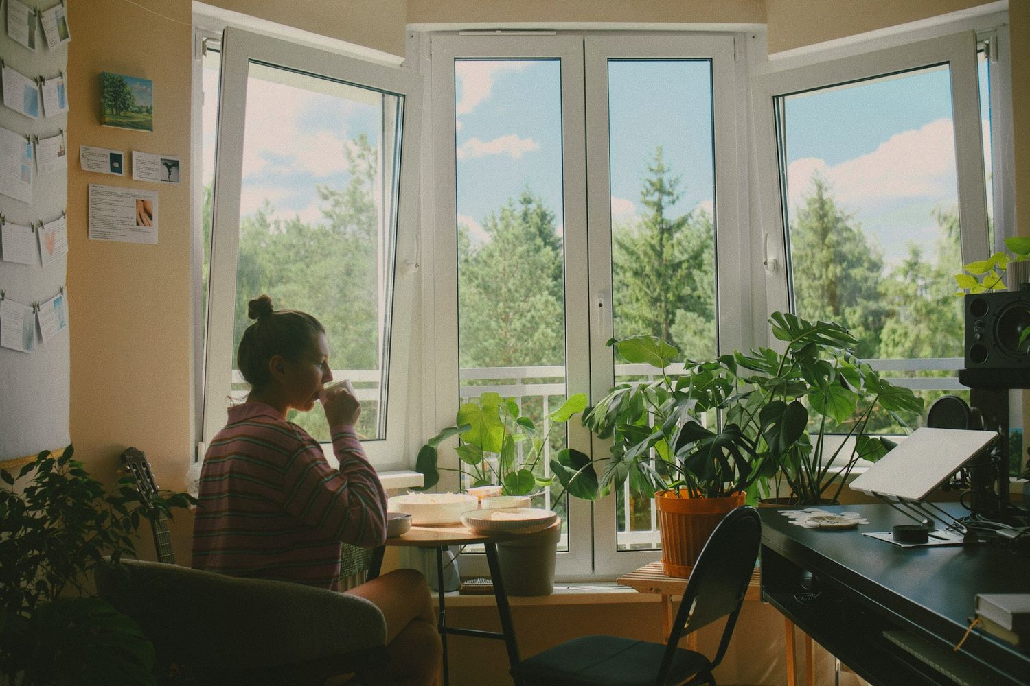 A person journaling in a notebook by a window in warm morning light